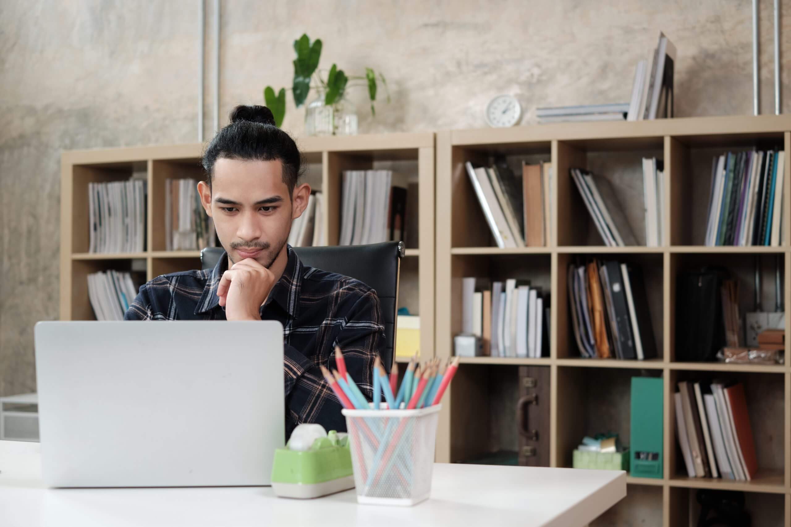 man working with bookshelf in the background