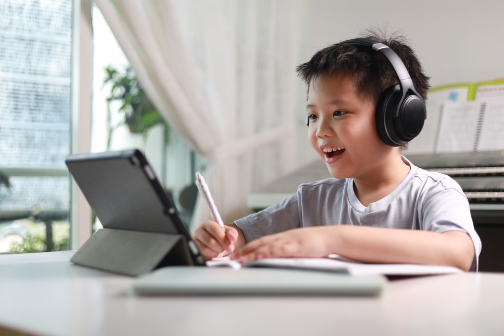 Portrait,Of,A,Little,Asian,Boy,Using,Tablet,Computer,And