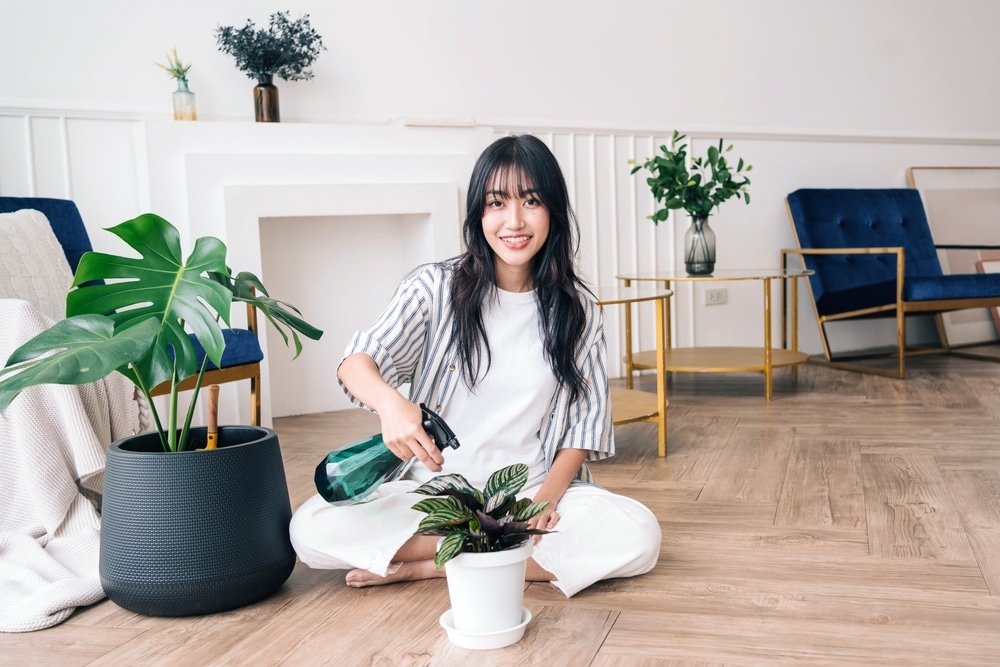 woman taking care of plant in the condo to achieve sustainable living