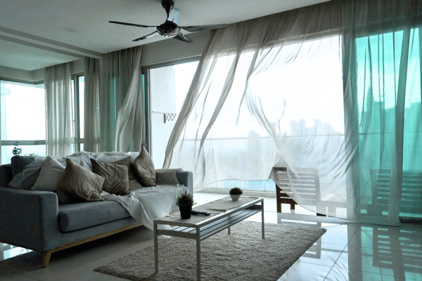 condo unit with the window open and the curtains billowing in the middle of a storm