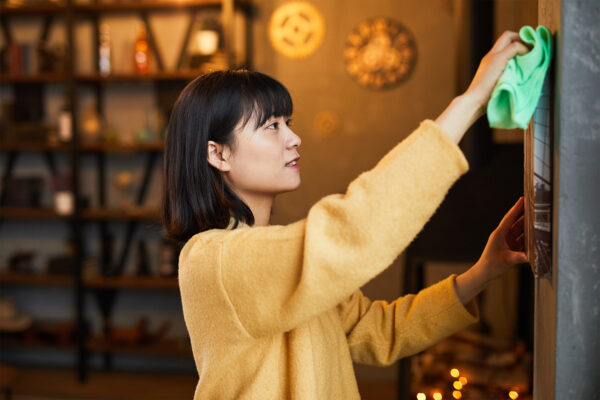 Side view portrait of young Asian woman cleaning home apartment