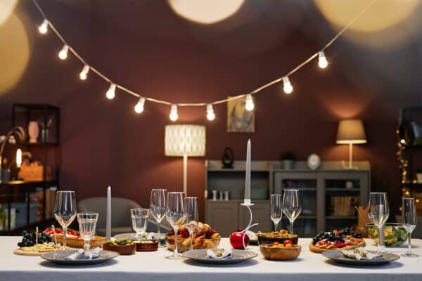 Dinner table served with appetizing homemade food, candles and flutes