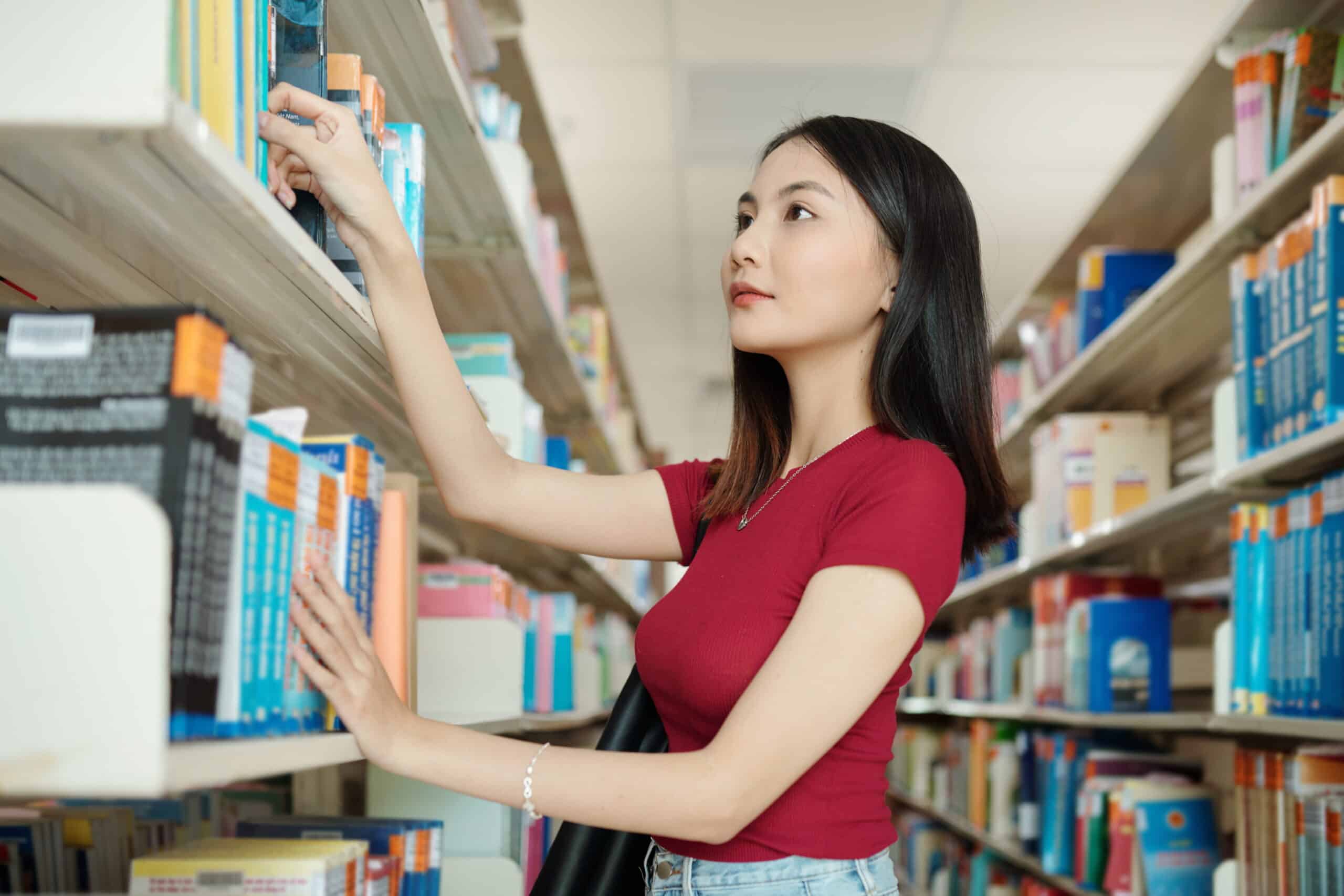 college student searching books in library