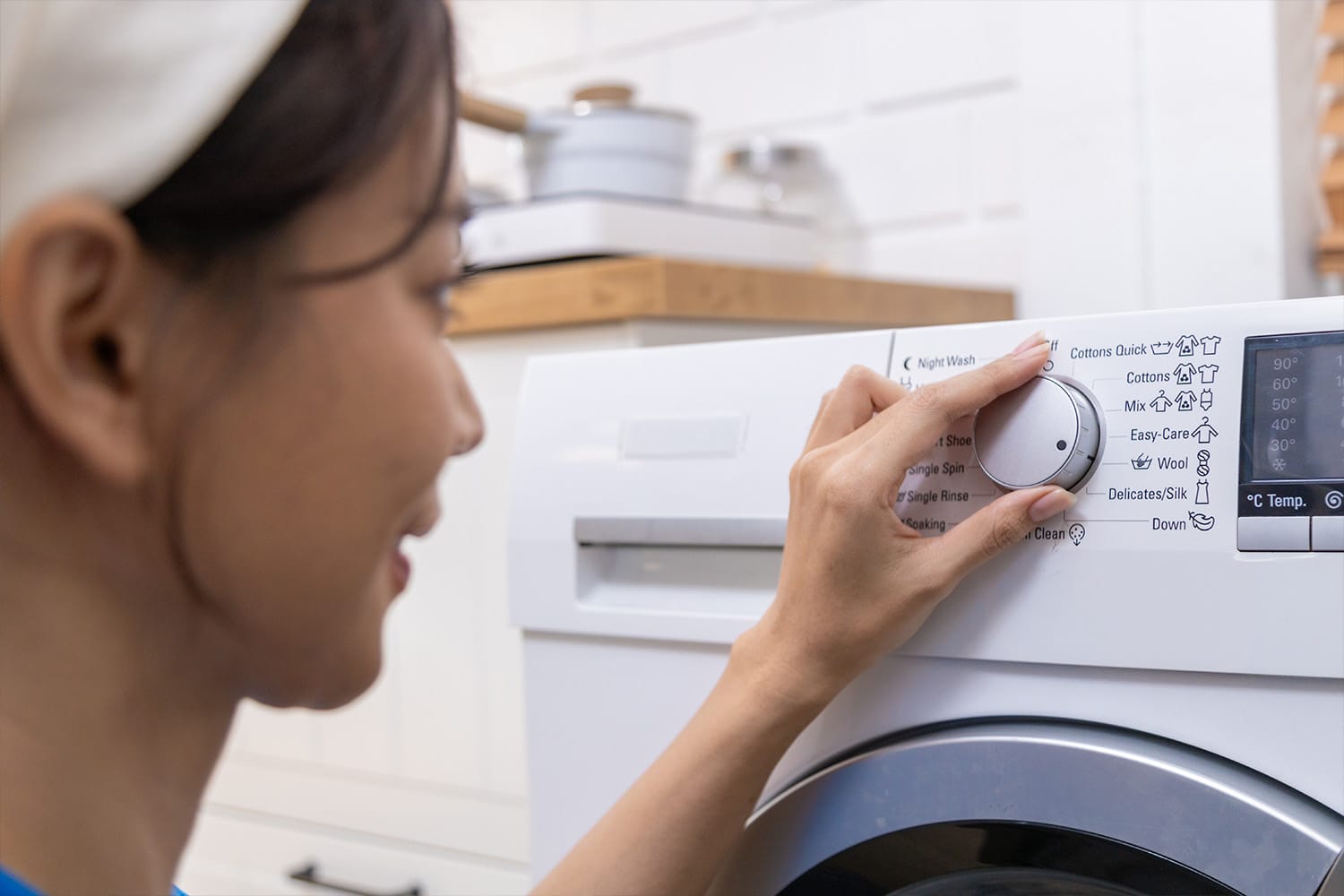 woman adjusting washing machine knob