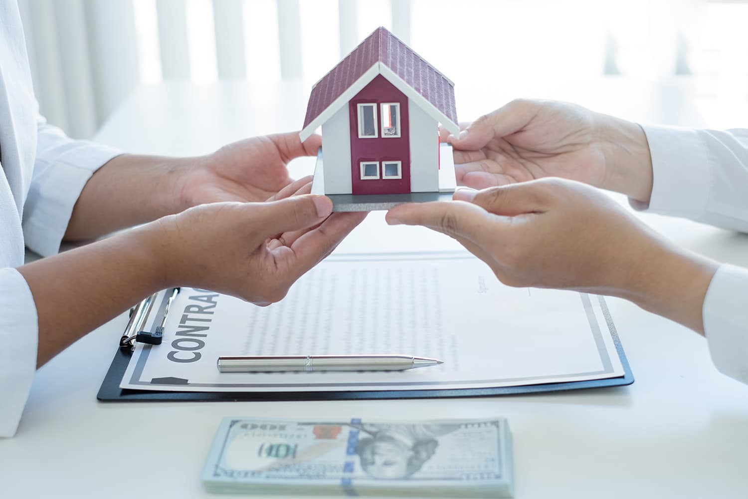 people holding a miniature house